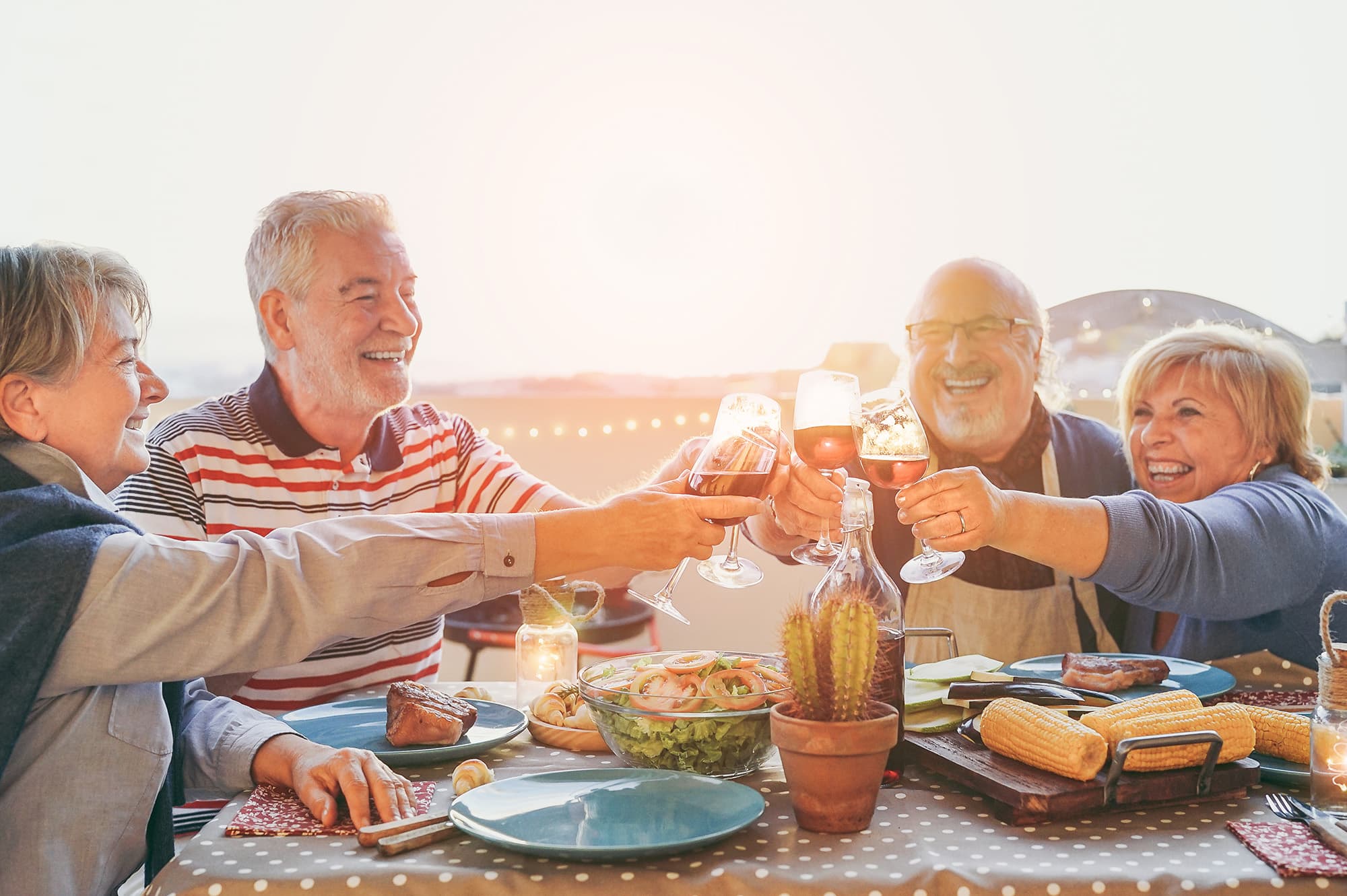 A group of residents at an outdoor table at our 55 and over community in Austin, TX, featuring food on the table.